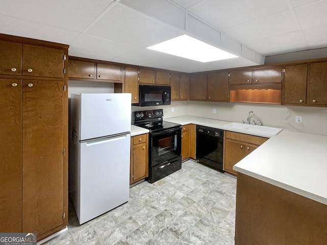 kitchen with light floors, open shelves, a sink, light countertops, and black appliances