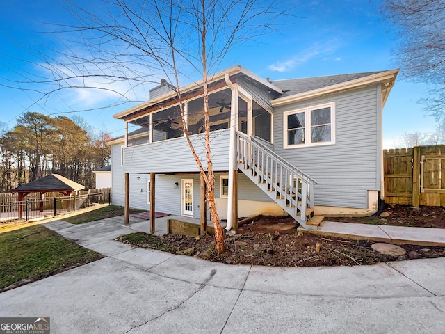 exterior space with a sunroom, stairway, fence, and a patio