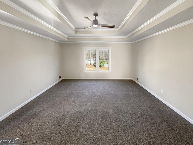 unfurnished room featuring crown molding, a raised ceiling, dark carpet, and baseboards