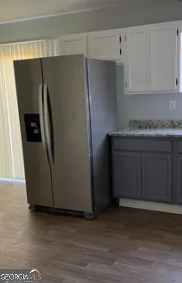 kitchen with white cabinetry, stainless steel refrigerator with ice dispenser, and wood finished floors