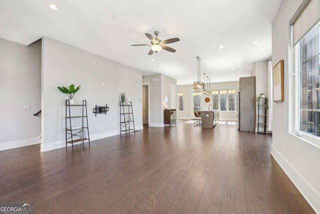 living room featuring dark wood-style flooring, recessed lighting, and baseboards