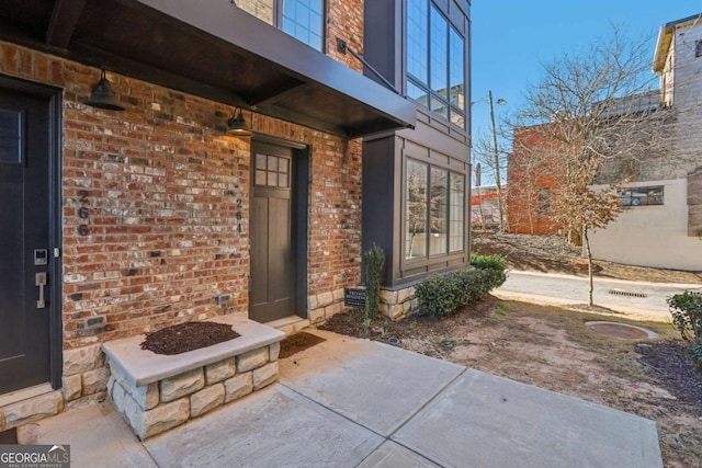 view of exterior entry with brick siding