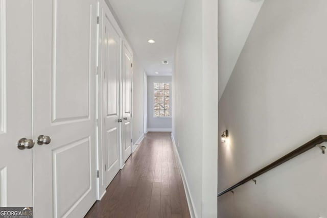 corridor with dark wood-style floors, baseboards, and recessed lighting