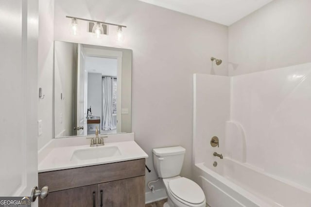 bathroom featuring washtub / shower combination, vanity, and toilet