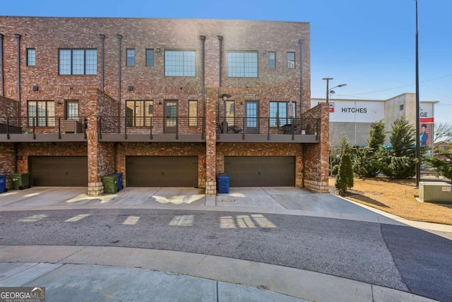 townhome / multi-family property featuring a garage and brick siding