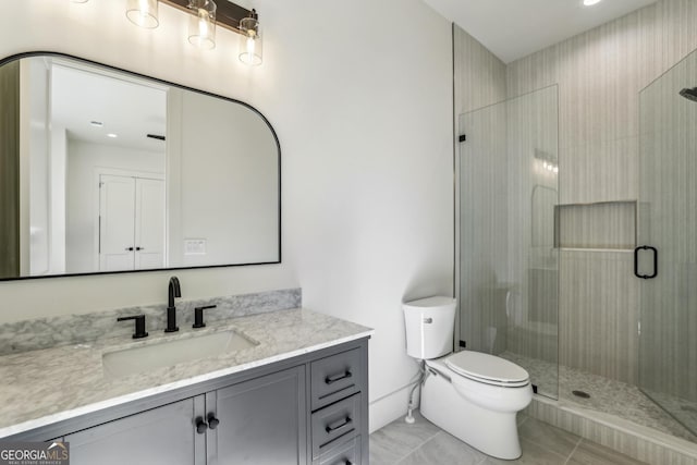 full bath featuring a stall shower, vanity, and toilet