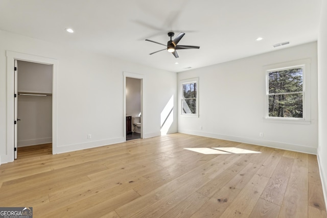 unfurnished bedroom featuring recessed lighting, visible vents, a spacious closet, light wood-type flooring, and baseboards