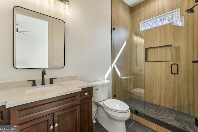 bathroom with toilet, a stall shower, tile patterned floors, and vanity