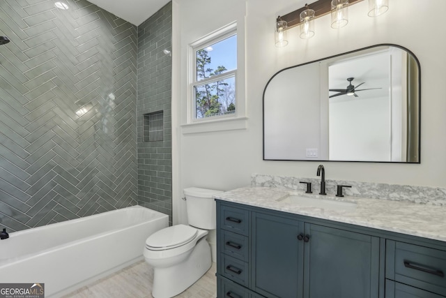 bathroom with shower / bath combination, ceiling fan, vanity, and toilet