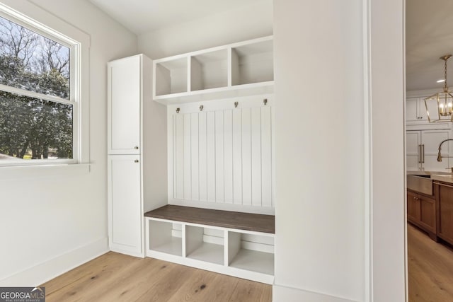 mudroom with light wood-type flooring, baseboards, a chandelier, and a wealth of natural light