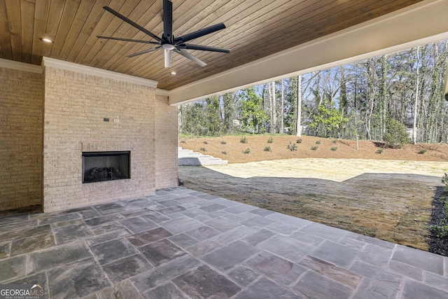 view of patio / terrace with an outdoor brick fireplace and a ceiling fan