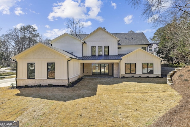 rear view of house with metal roof, a standing seam roof, french doors, board and batten siding, and brick siding