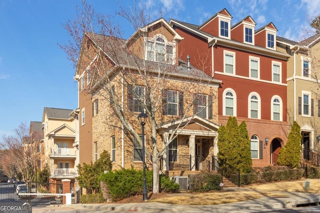 townhome / multi-family property featuring brick siding and central AC unit