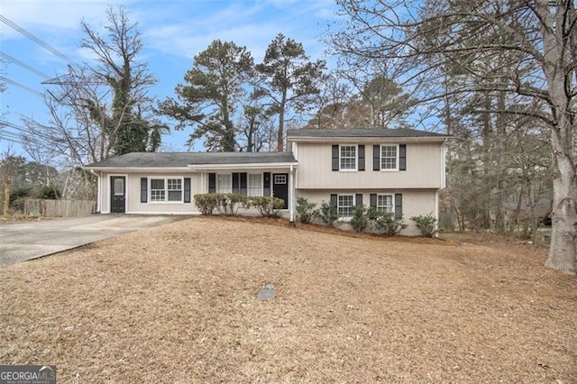 tri-level home with concrete driveway and brick siding