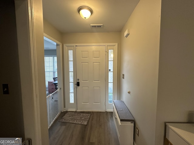 foyer entrance with visible vents and dark wood-style flooring