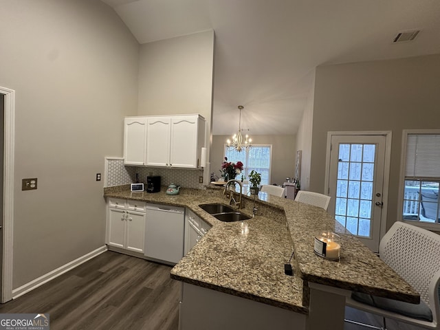 kitchen featuring vaulted ceiling, white dishwasher, a peninsula, and a sink