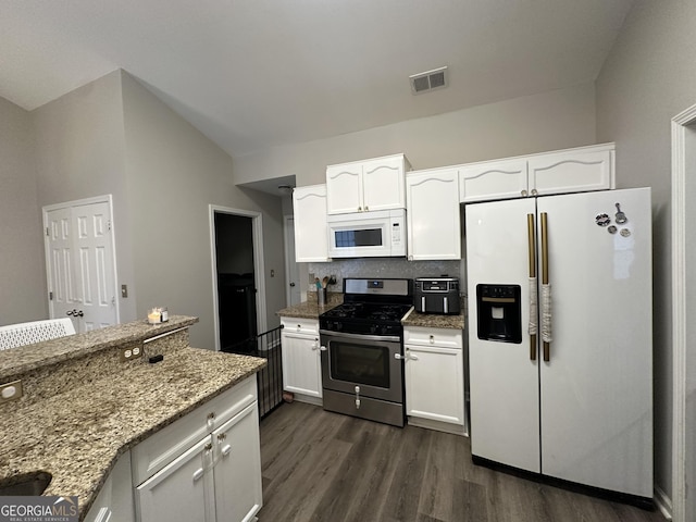 kitchen with light stone counters, white appliances, visible vents, and white cabinets