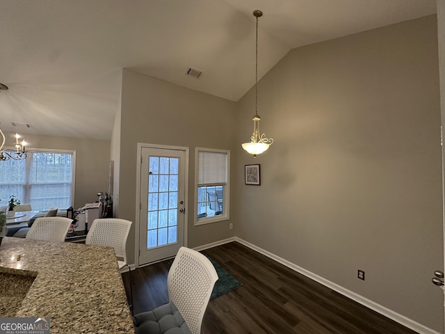 dining room featuring baseboards, visible vents, dark wood-style floors, an inviting chandelier, and high vaulted ceiling