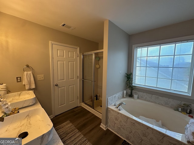 bathroom with a garden tub, wood finished floors, vanity, visible vents, and a stall shower