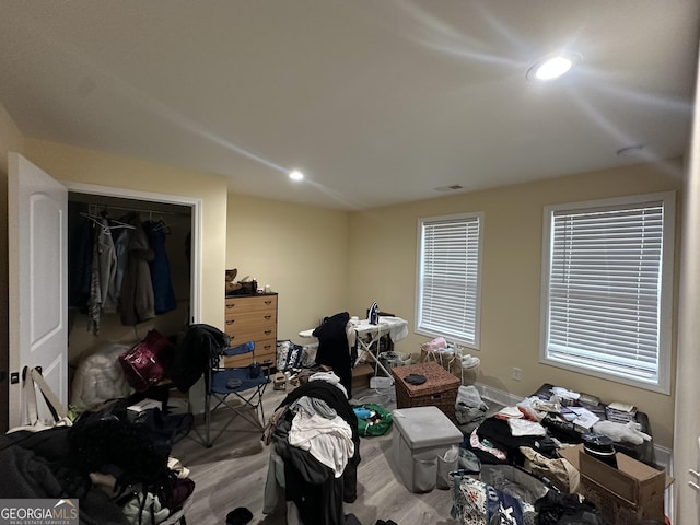 bedroom with a closet, wood finished floors, visible vents, and recessed lighting