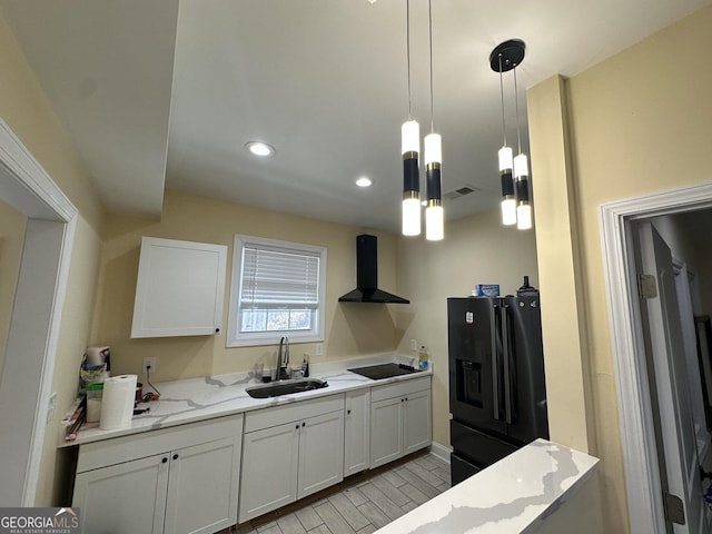 kitchen featuring visible vents, light stone counters, black appliances, a sink, and exhaust hood