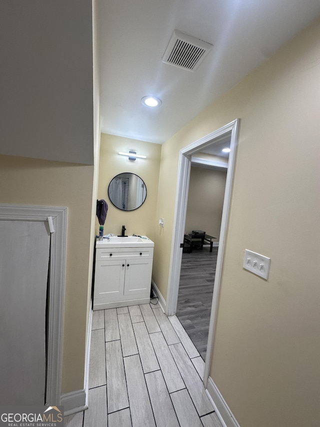 bathroom featuring visible vents, baseboards, wood tiled floor, vanity, and recessed lighting