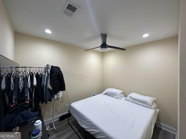 bedroom with wood finished floors, visible vents, and baseboards