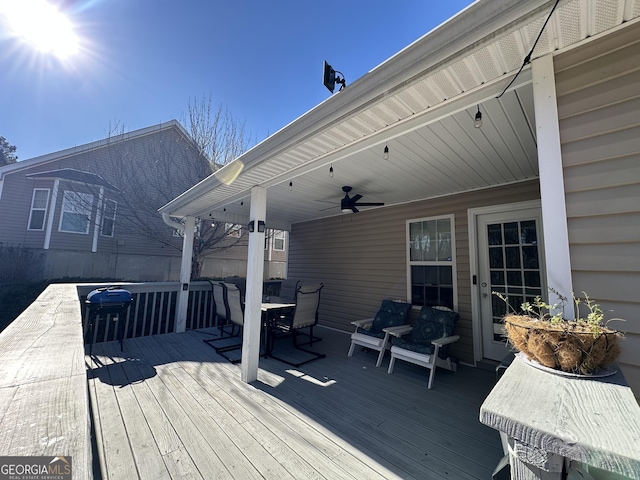 wooden deck featuring ceiling fan and outdoor dining area