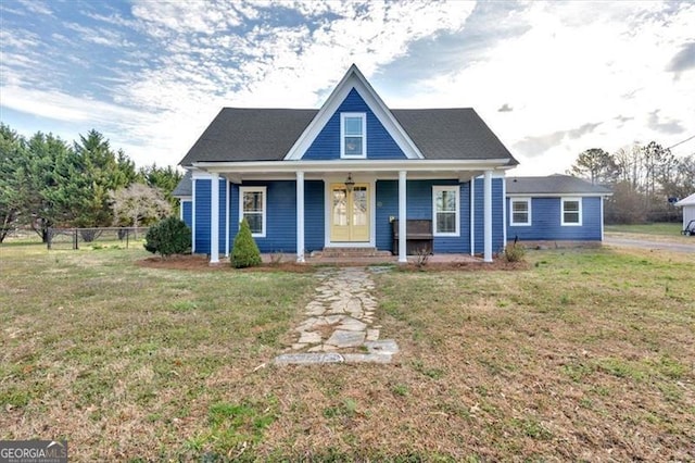 view of front of home featuring a porch, fence, and a front lawn