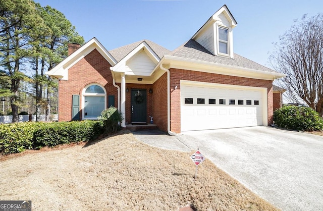 view of front of house featuring an attached garage, a shingled roof, concrete driveway, and brick siding