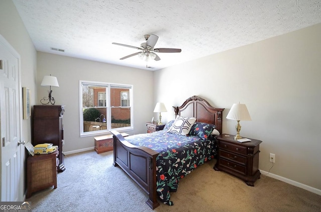 carpeted bedroom featuring visible vents, ceiling fan, a textured ceiling, and baseboards