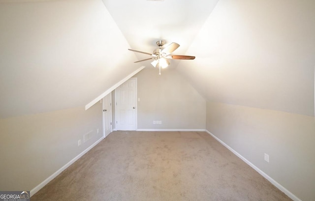 bonus room featuring lofted ceiling, carpet flooring, a ceiling fan, and baseboards