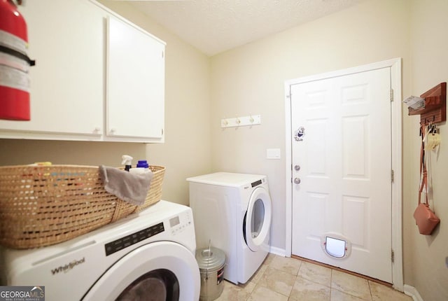 clothes washing area with a textured ceiling, baseboards, cabinet space, and washer and dryer