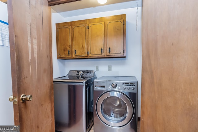 clothes washing area with cabinet space and independent washer and dryer