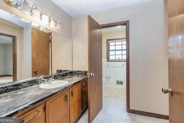 bathroom with visible vents, baseboards, toilet, tile patterned flooring, and vanity