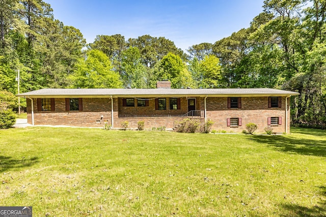 ranch-style house with brick siding, a chimney, and a front yard