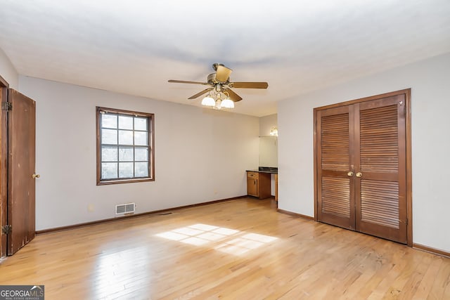 unfurnished bedroom with light wood-type flooring, baseboards, visible vents, and a closet