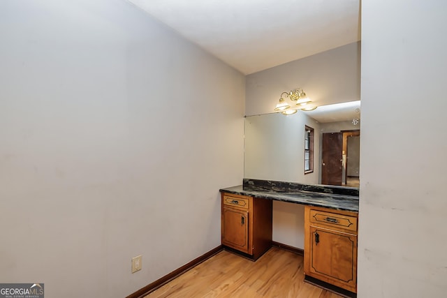 bathroom with wood finished floors, vanity, and baseboards