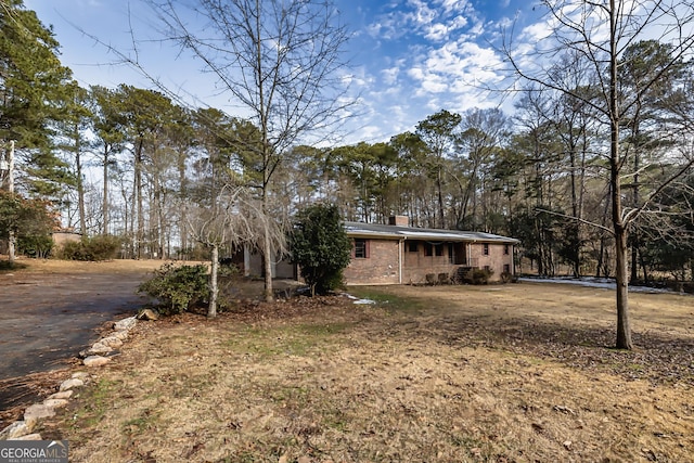 view of front of house with brick siding and a chimney