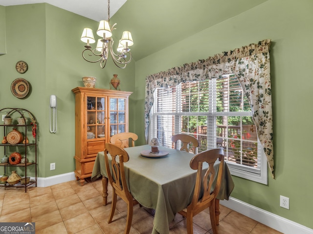 dining room featuring light tile patterned floors, vaulted ceiling, baseboards, and a notable chandelier