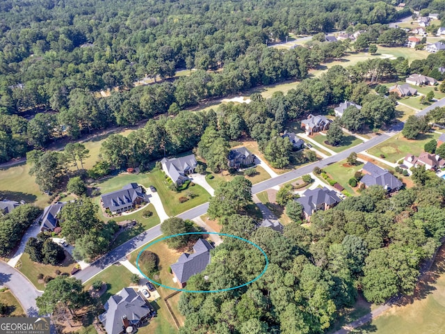 drone / aerial view featuring a wooded view and a residential view