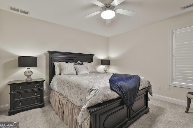 bedroom with a ceiling fan, visible vents, light carpet, and baseboards