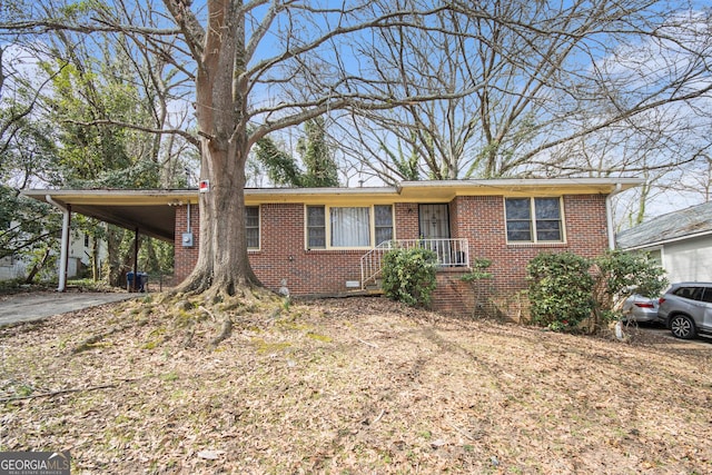 ranch-style home featuring an attached carport, brick siding, and driveway