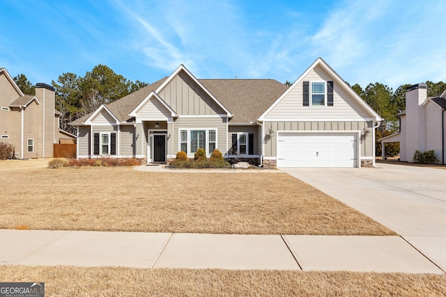 craftsman-style house with roof with shingles, concrete driveway, board and batten siding, a garage, and a front lawn