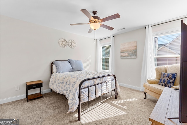 carpeted bedroom with baseboards, visible vents, and a ceiling fan