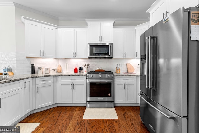 kitchen with ornamental molding, high end appliances, and white cabinets