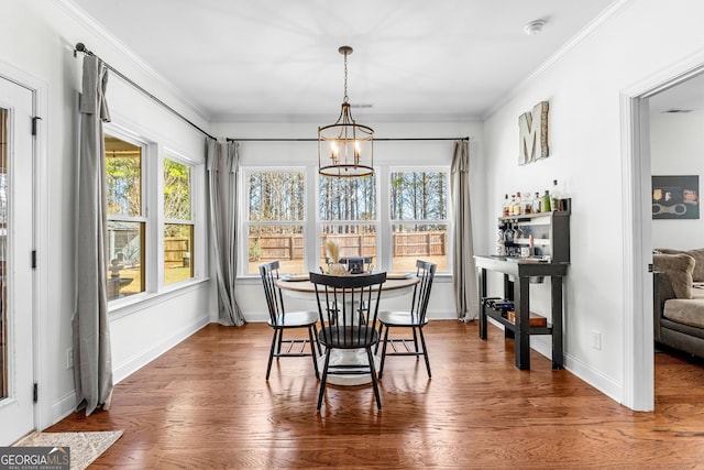 dining area featuring ornamental molding, plenty of natural light, and wood finished floors