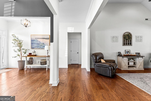 foyer entrance with baseboards, ornamental molding, a chandelier, and wood finished floors