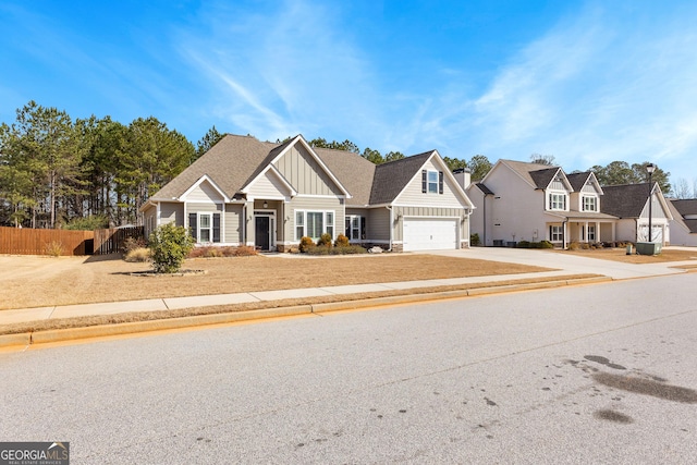 view of front of property with a shingled roof, fence, driveway, stone siding, and board and batten siding