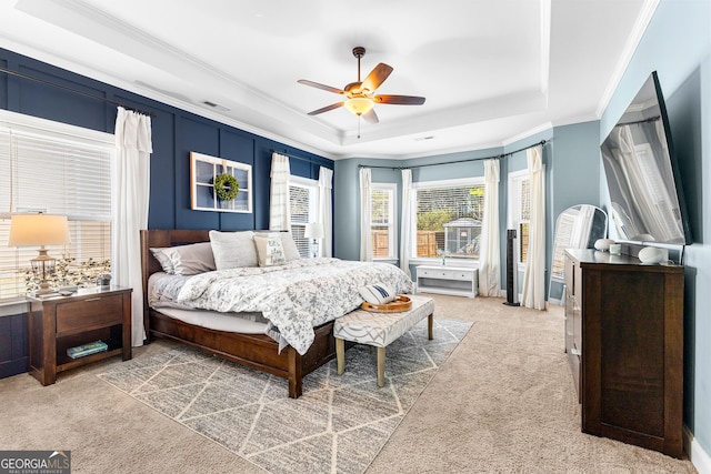 bedroom featuring carpet floors, visible vents, a tray ceiling, and ornamental molding